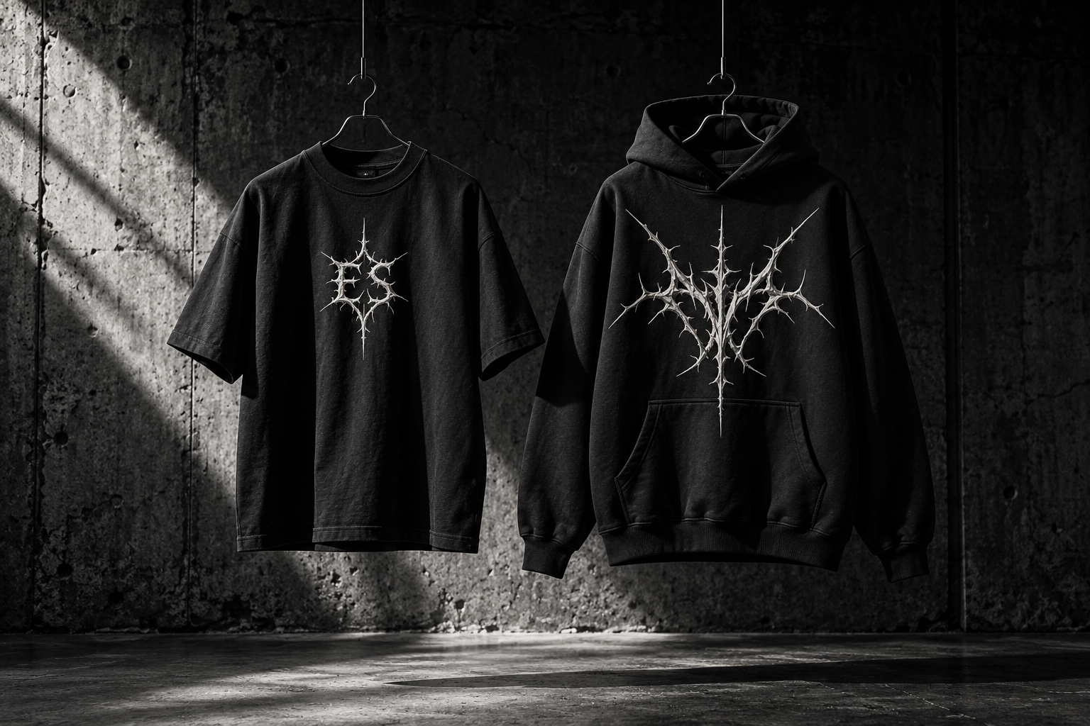 Concept black tee and hoodie with ivory gothic ES graphics in a dark studio